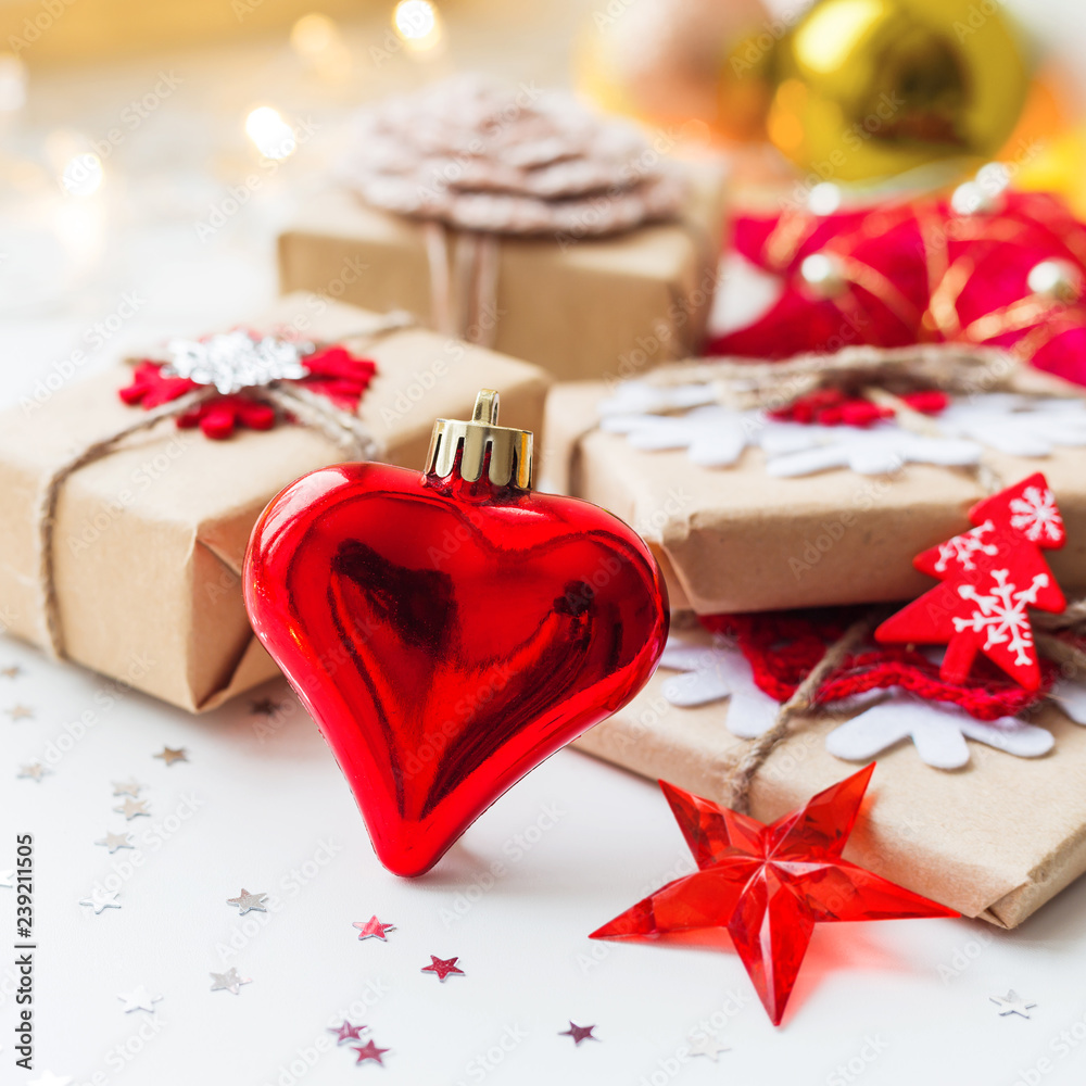 Christmas and New Year background with red decorative heart, presents and decorations for Christmas tree. Holiday background with stars confetti and light bulbs. Place for text. Christmas and New Year background with red decorative heart, presents and decorations for Christmas tree. Holiday background with stars confetti and light bulbs. Place for text.