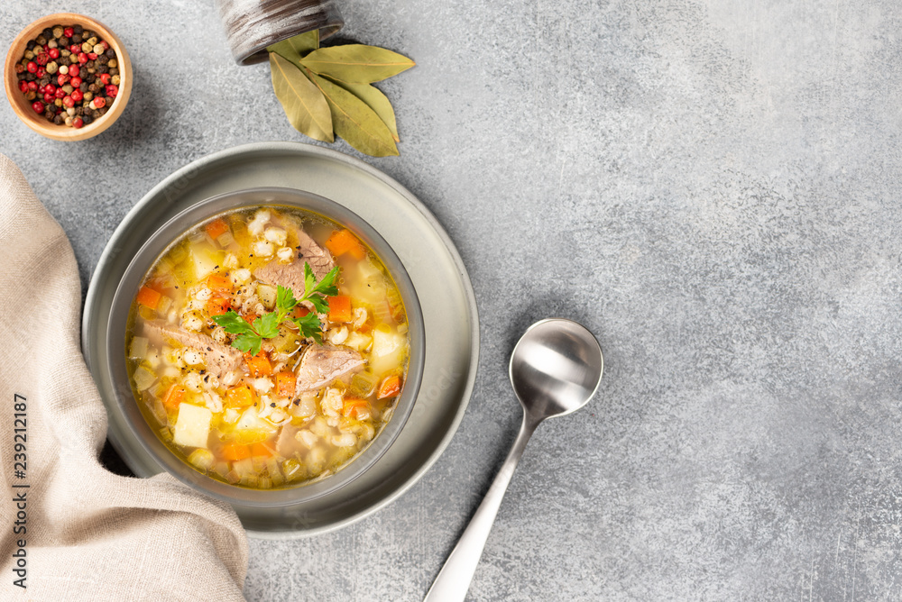 Rassolnik - Traditional Russian soup with pickled cucmbers, pearl barley, meat, pickles, carrots and potatoes on light background. Top view