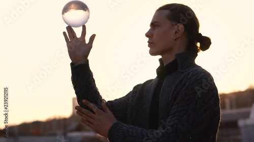 Contact juggling. Man juggle clear acrylic ball on background of urban landscape. Skyline. Magic of movement. Performance in street.