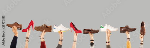 arms raised and holding shoes