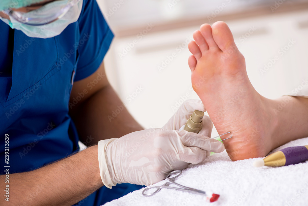Podiatrist treating feet during procedure Podiatrist treating feet during procedure