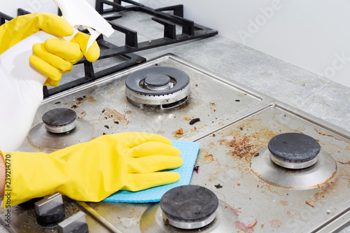 Cleaning a gas stove with kitchen utensils, household concepts, or hygiene and cleaning.