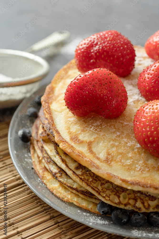 Pancakes with strawberries on a plate. Sweet breakfast or snack.