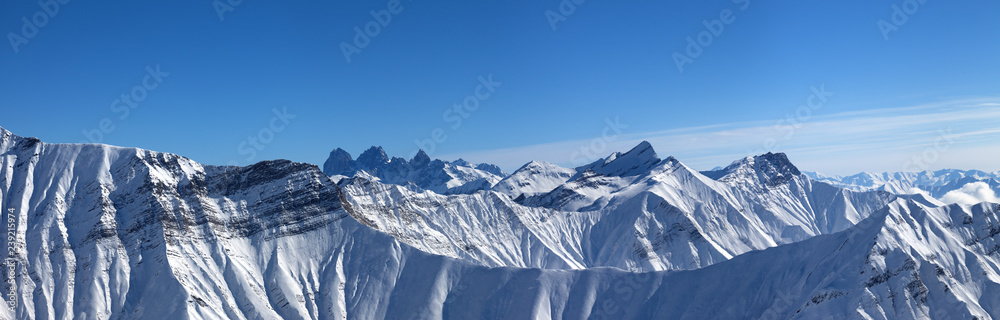 Large panorama of snowy mountains and blue sky