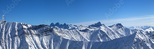Large panorama of snowy mountains and blue sky © BSANI
