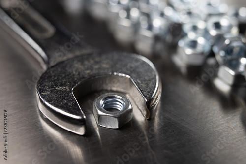 Wrench and nuts on a metal table in a workshop. Accessories for mechaics for minor mechanical repairs. photo