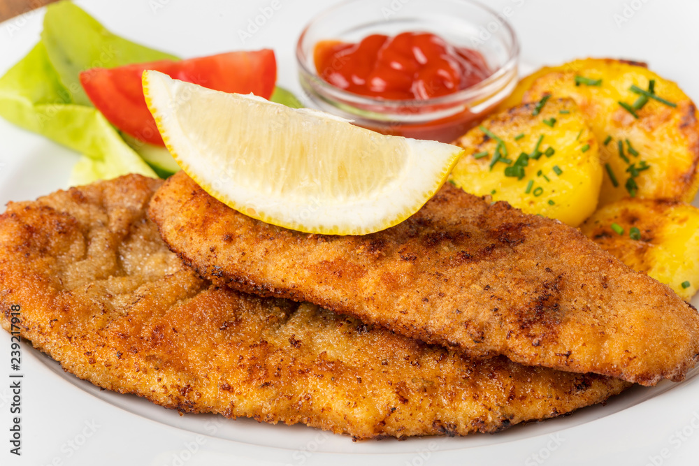 Nahaufnahme von einem Wiener Schnitzel mit Kartoffeln Nahaufnahme von einem Wiener Schnitzel mit Kartoffeln