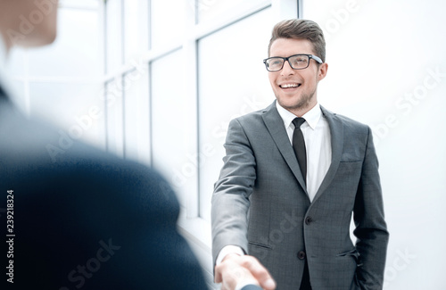 Manager greets the client with a handshake.