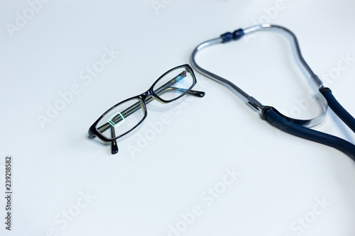 Stethoscope and closeup glasses on white background