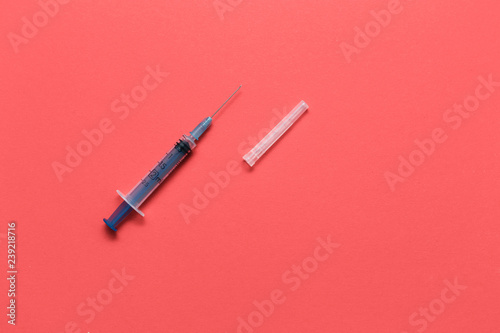 Medical syringe closeup on red background