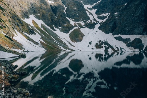Fototapeta Naklejka Na Ścianę i Meble -  Mystical reflection of snow and mountains in water of Czarny Staw Black Pond, Tatra Mountains, Poland