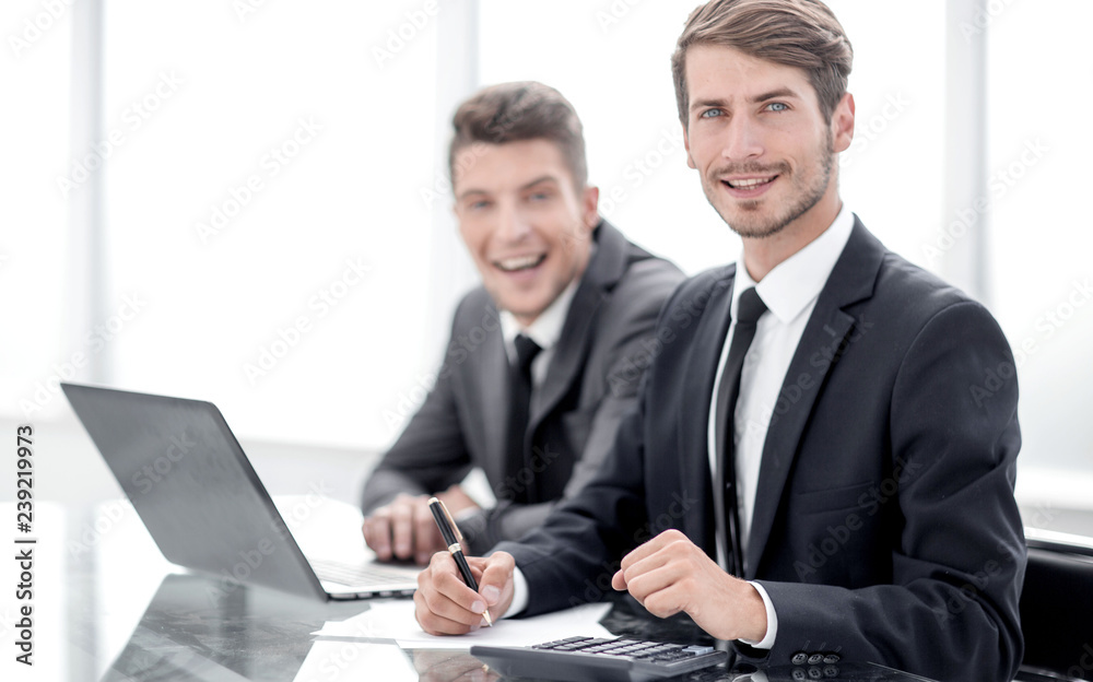 Image of two young businessmen using laptop at meeting Image of two young businessmen using laptop at meeting