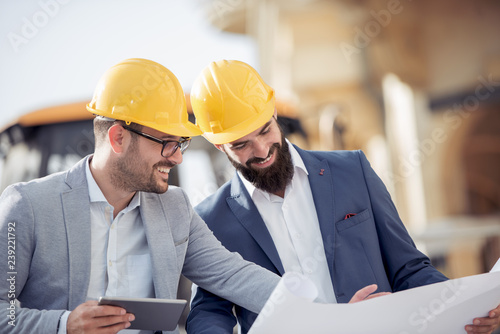 Two engineers  in hardhat using a tablet