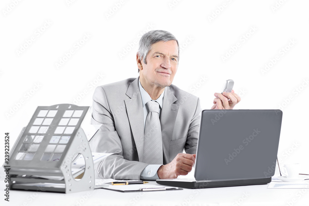 smiling senior businessman at his workplace.isolated on a white