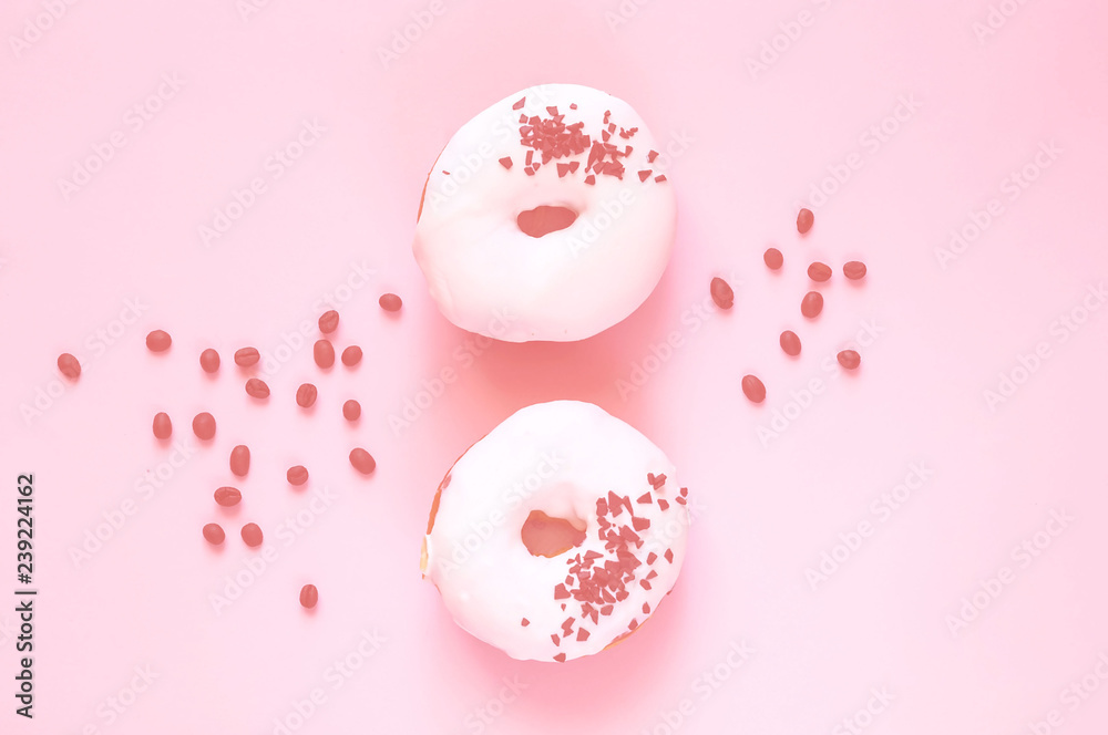 White glazed donut  with black chocolate sweets on colar background. Flat lay. Food concept, colorful breakfast. Color of 2019. 