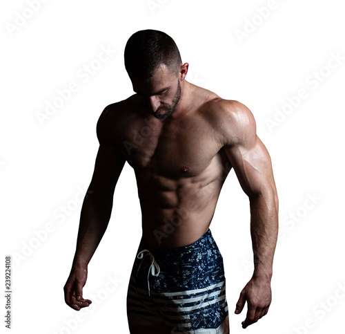Athletic man with a muscular body poses, showing off his muscles. The concept of a healthy lifestyle on white background