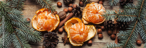 Tangerines, Christmas tree branches, cones, spices on a wooden background. Сoncept of New Year and Christmas, Christmas drink Mulled wine. Flat lay, top view. Banner