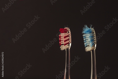 Used and new toothbrushes on a black background. The concept of changing toothbrushes, oral hygiene, dentistry. Family