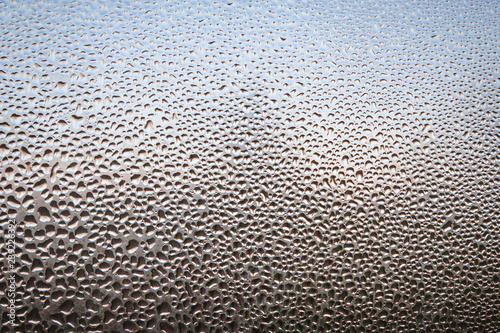 The frozen drops on the patterned frosty winter window