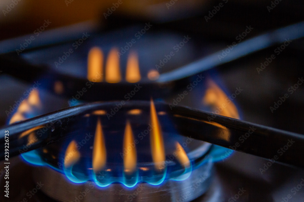 Gas stove with burning orange and blue fire on it
