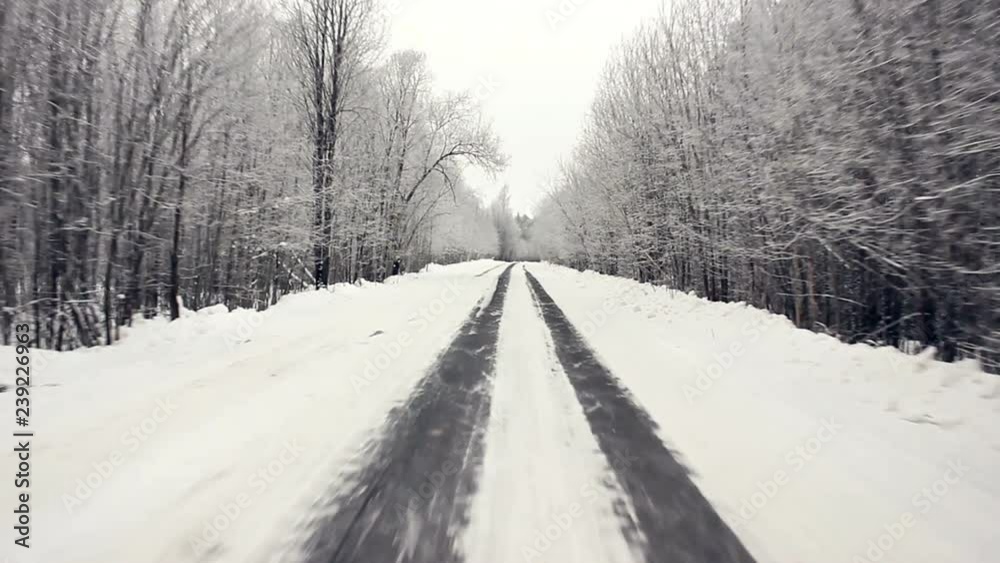 Driving through the winter forest on snowy road, first view. Camera outside the window on steadicam. Driving pov at the first snow of winter on a beautiful mountain fir forest road. Driving through the winter forest on snowy road, first view. Camera outside the window on steadicam. Driving pov at the first snow of winter on a beautiful mountain fir forest road.