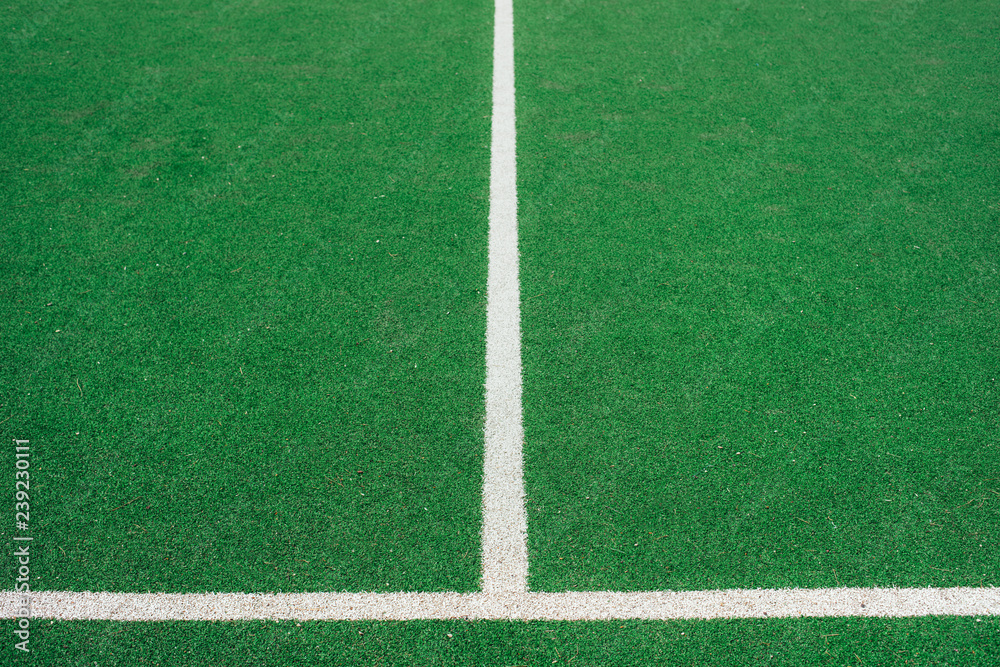 Obraz premium White lines on green soccer or football field. Perpendicular lining.