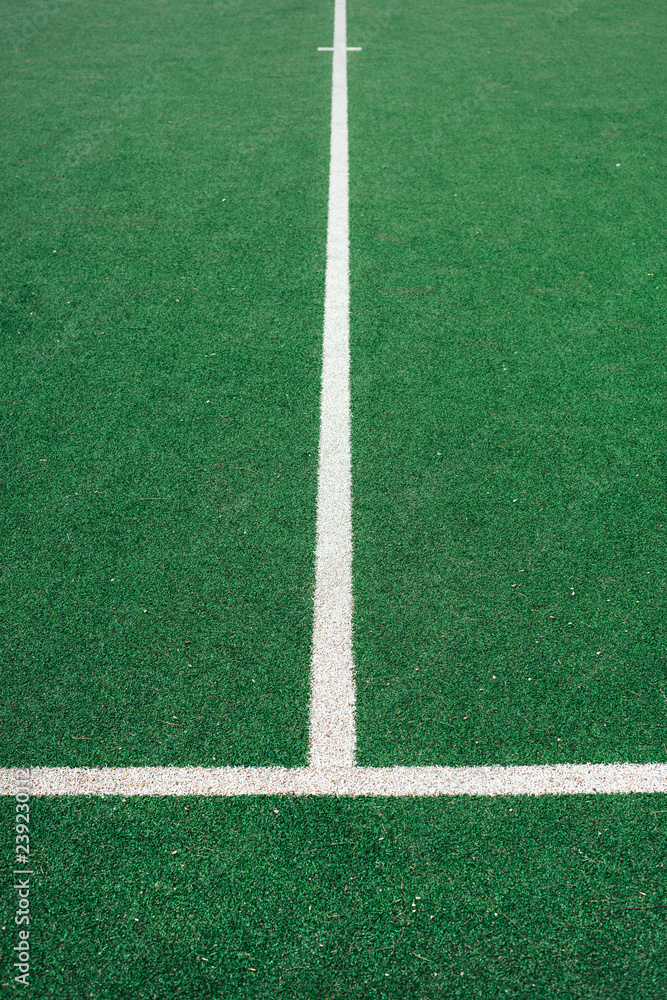 White lines on green soccer or football field. Perpendicular lining.