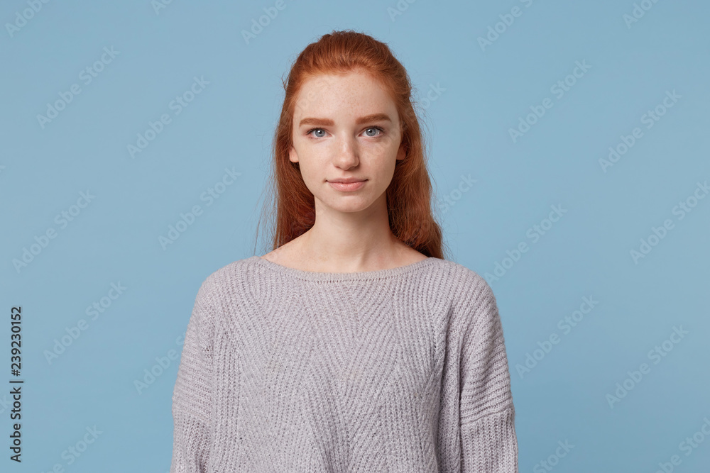Young Beautiful Girl With Long Red Hair And Blue Eyes With Freckles Looks Straight Into The Camera Feels Calm And Confidently Isolated On A Blue Background Stock Photo Adobe Stock