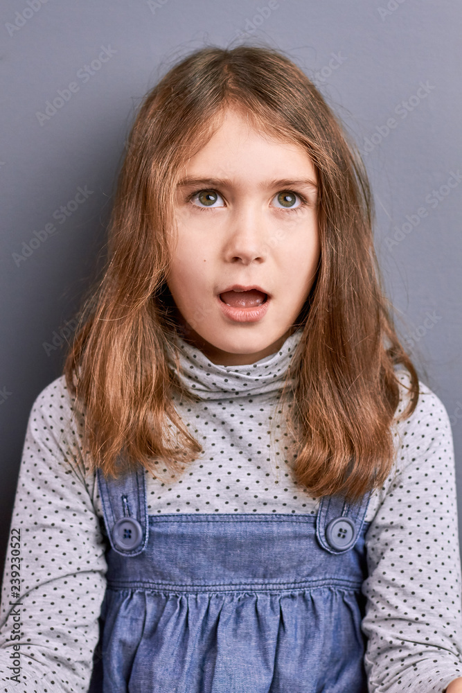 Cute little girl opens mouth. Portrait of surprised little girl on grey  background. Kids expressions of amazement. European little model. Stock  Photo | Adobe Stock