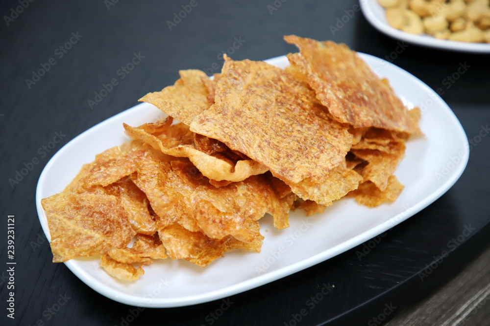 crispy sliced pork in white plate On the black wood table crispy sliced pork in white plate On the black wood table