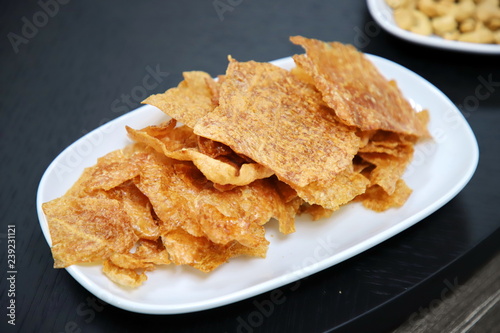 crispy sliced pork in white plate On the black wood table