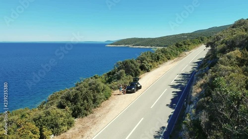 Wallpaper Mural Aerial view of a turists - couple stopping by the road for a better view of Adriatic sea and Croatian islands. The woman is pointing towards something with her finger. Torontodigital.ca