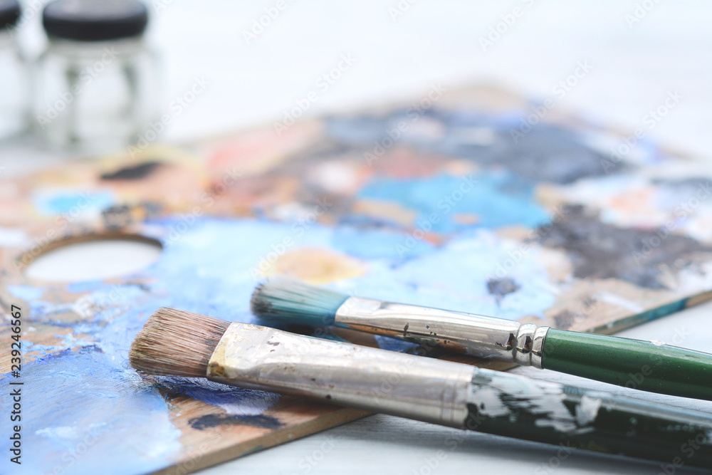 Artist's palette with colorful oil paint strokes and paintbrushes