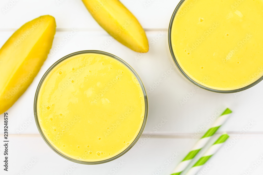 Frischer Smoothie aus Mango und Joghurt in Gläser, fotografiert auf weissem Holz (Selektiver Fokus, Fokus auf die Oberfläche der Smoothies) Frischer Smoothie aus Mango und Joghurt in Gläser, fotografiert auf weissem Holz (Selektiver Fokus, Fokus auf die Oberfläche der Smoothies)