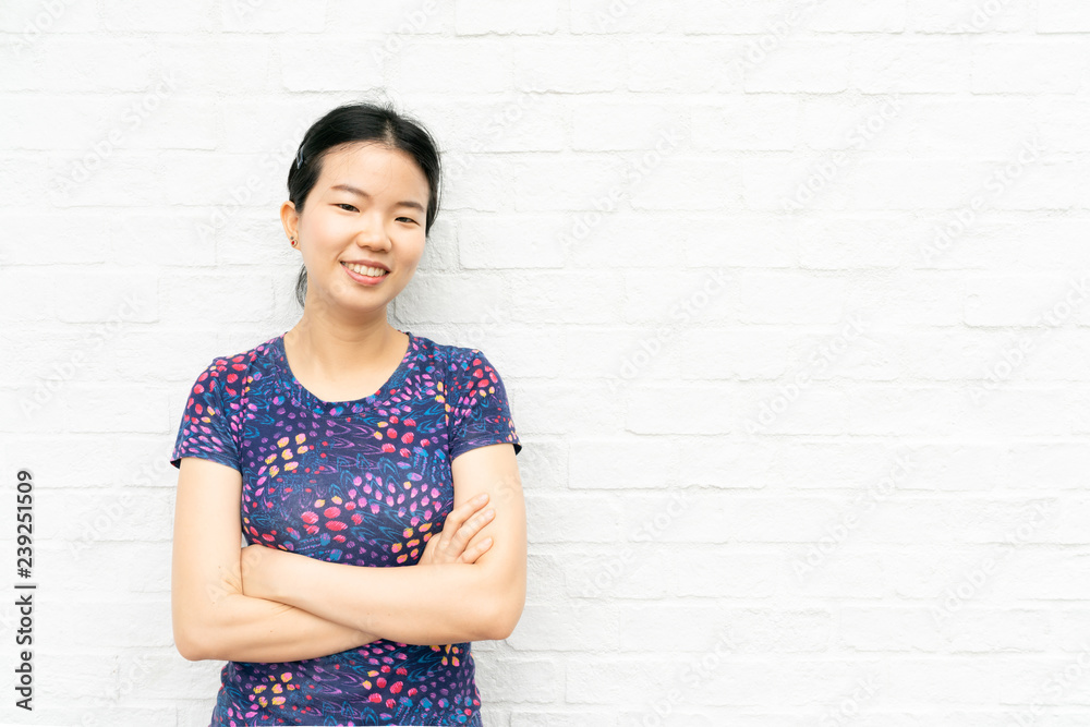 Young Asian pretty casual woman and crossed her arms. indicate blank space on white brick wall background. - happy woman. Young Asian pretty casual woman and crossed her arms. indicate blank space on white brick wall background. - happy woman.