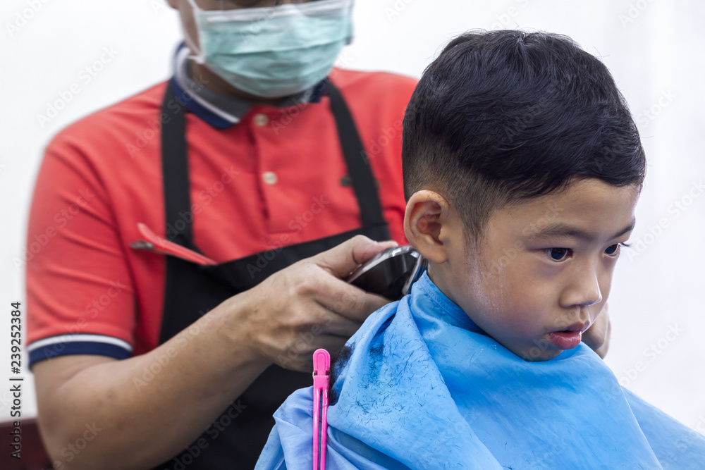 Little Asian boy and black hair age 4 years old getting haircut with barber  man for prepare back to school on white background Stock Photo | Adobe Stock