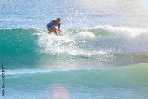 man in the ocean on a surfboard rides on top of a wave