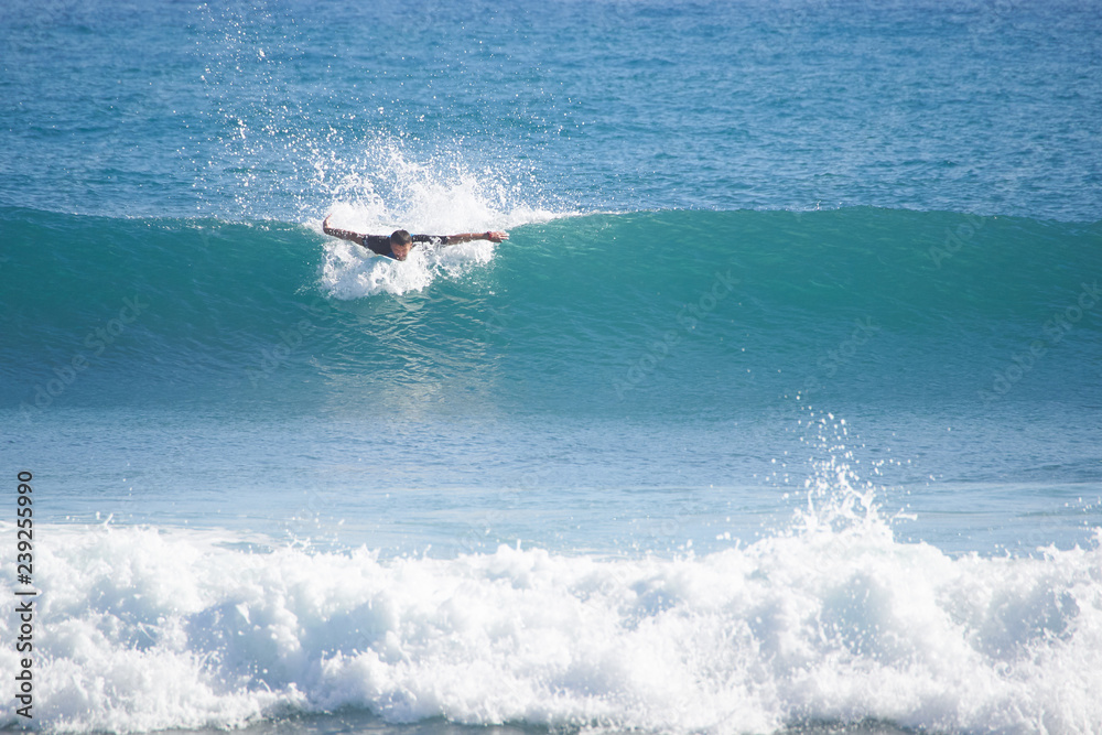 man surfer in the ocean catches the wave