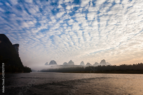 Canvas-taulu Early morning altocumulus clouds and river scene