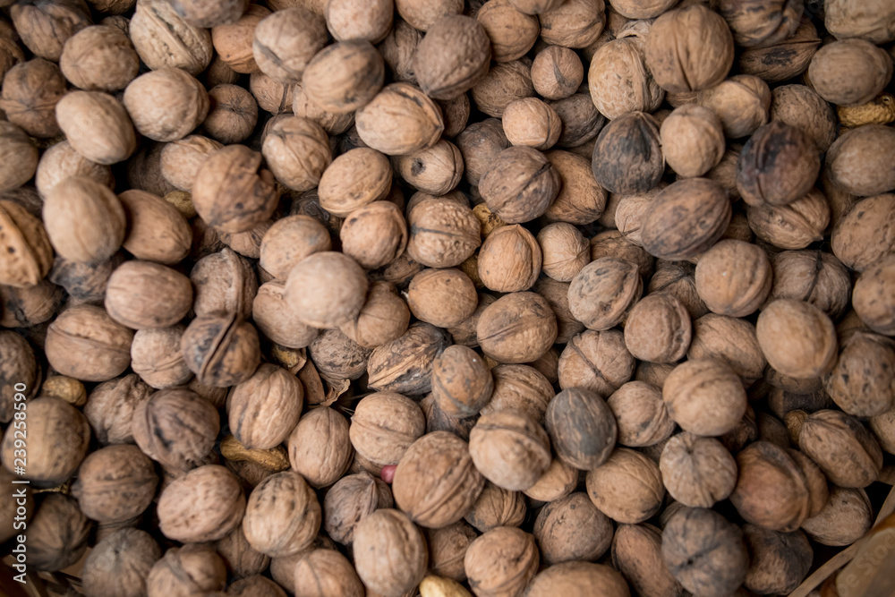 Walnuts background. Walnuts texture. Group walnuts on wooden background. Healthy organic food concept. Top view. View above Walnuts background. Walnuts texture. Group walnuts on wooden background. Healthy organic food concept. Top view. View above