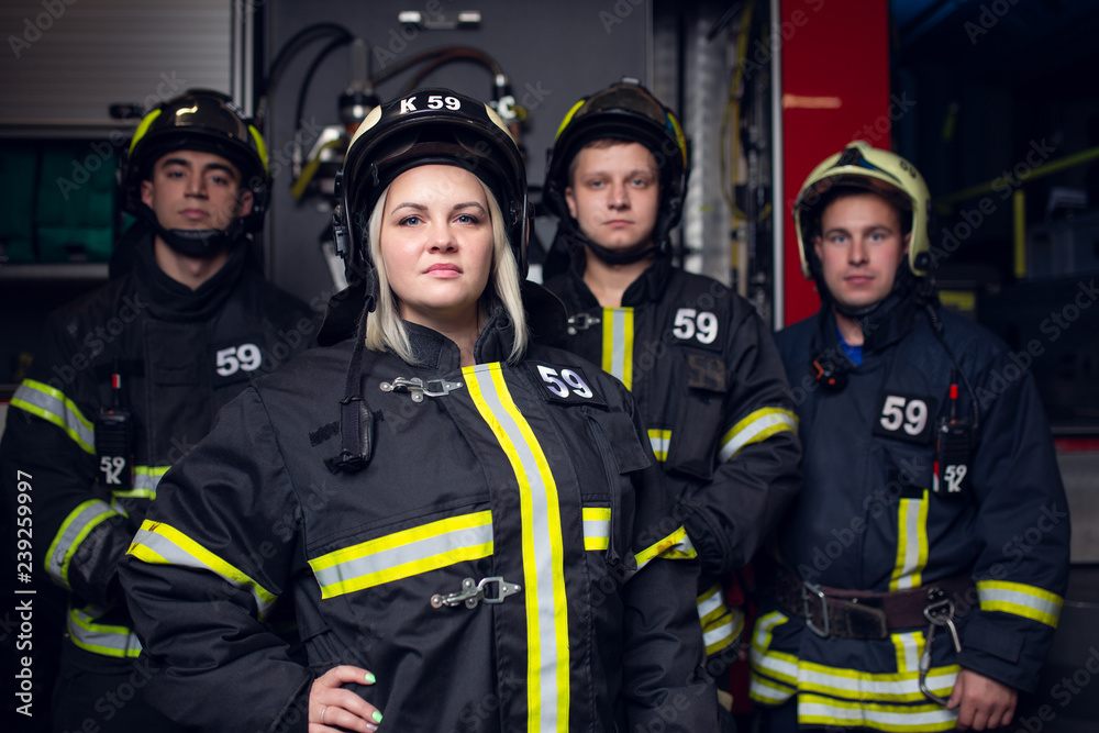 Image of three firemen men and woman on background of fire truck Image of three firemen men and woman on background of fire truck