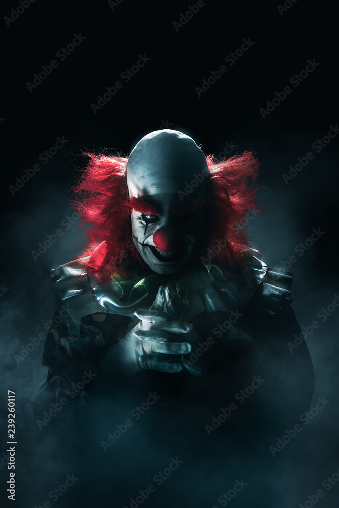 Scary clown on a dark background Scary clown on a dark background