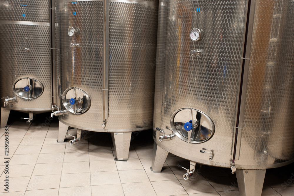 Modern wine factory with new large tanks for the fermentation. modern wine cellar with stainless steel tanks. Modern wine factory with new large tanks for the fermentation. modern wine cellar with stainless steel tanks.