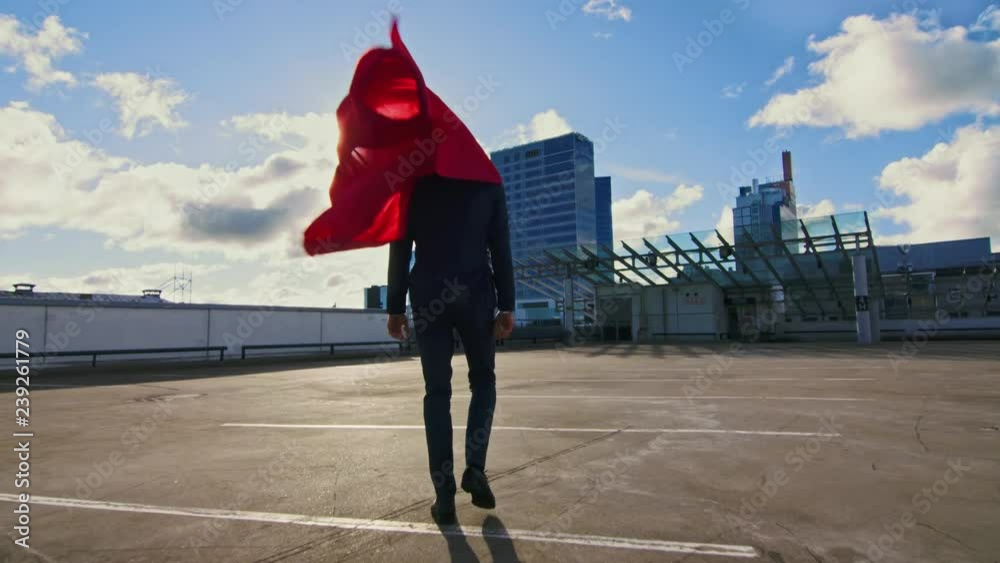 Businessman Superhero WIth Red Cape Blowing in the Wind Walks on the