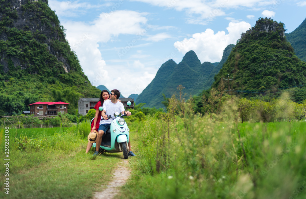 Couple riding motorbike around rice fields of Yangshuo, China Couple riding motorbike around rice fields of Yangshuo, China
