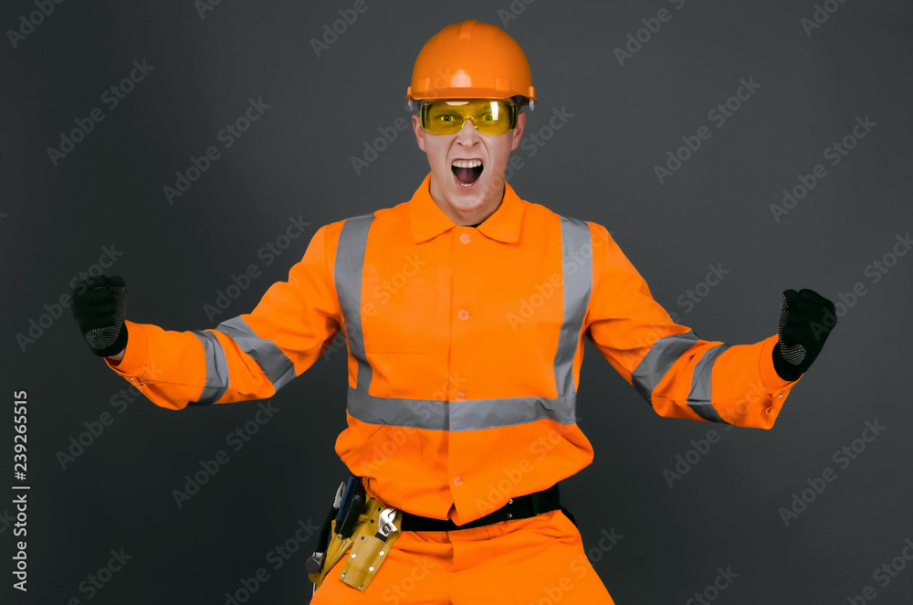 Fototapeta premium Angry builder foreman in the hardhat is shouting and screaming isolated on gray background. Construction problems.
