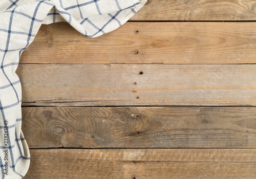 Blue and white checkered dishcloth on brown rustic wooden plank table flat lay top view from above
