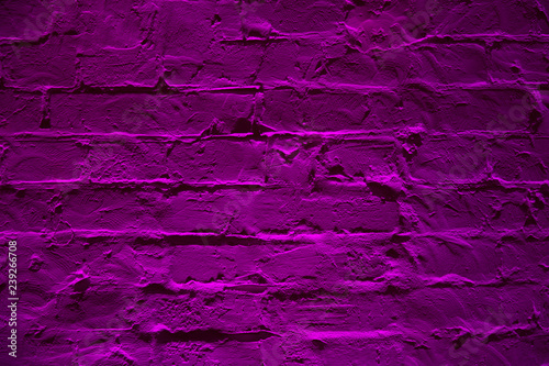 Grunge neon purple brick wall texture background. Magenta colored brick wall texture architexture pattern. photo