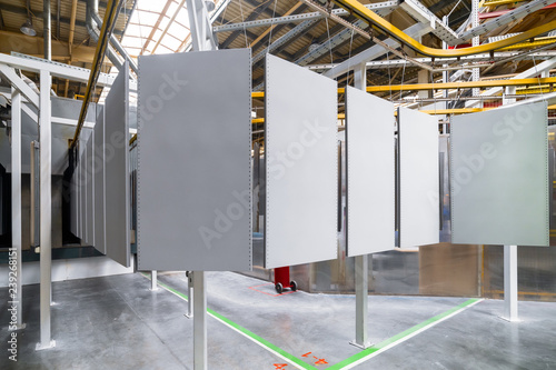 Powder coating line. Metal panels are suspended on an overhead conveyor line.