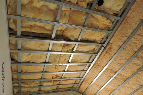 A metal frame of a ceiling under construction insulated with mineral wool 